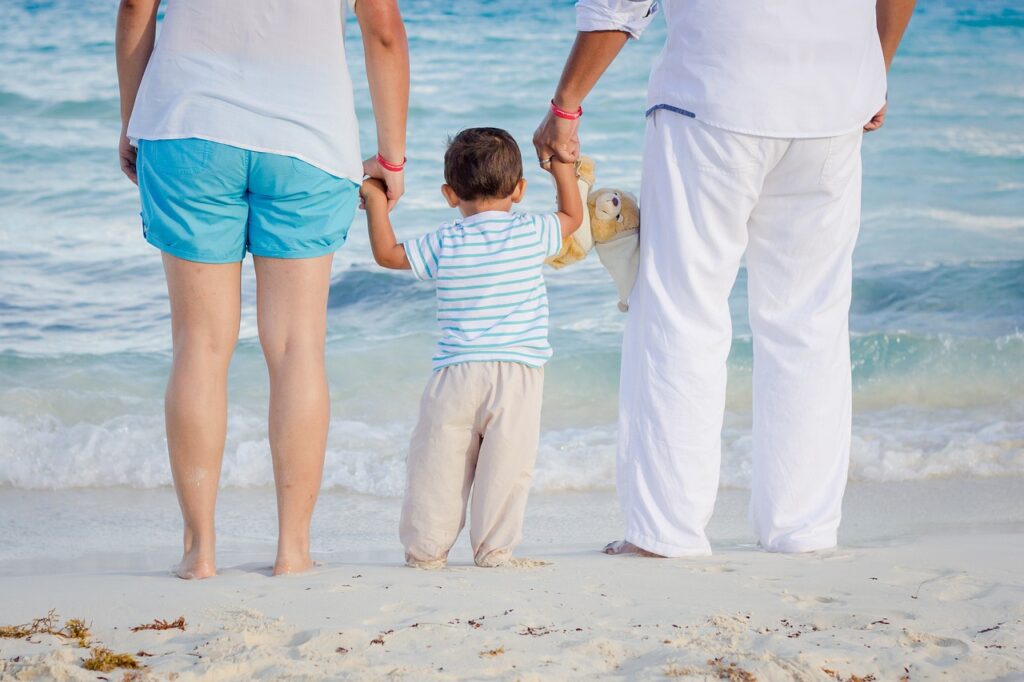 family holding hands at the beach