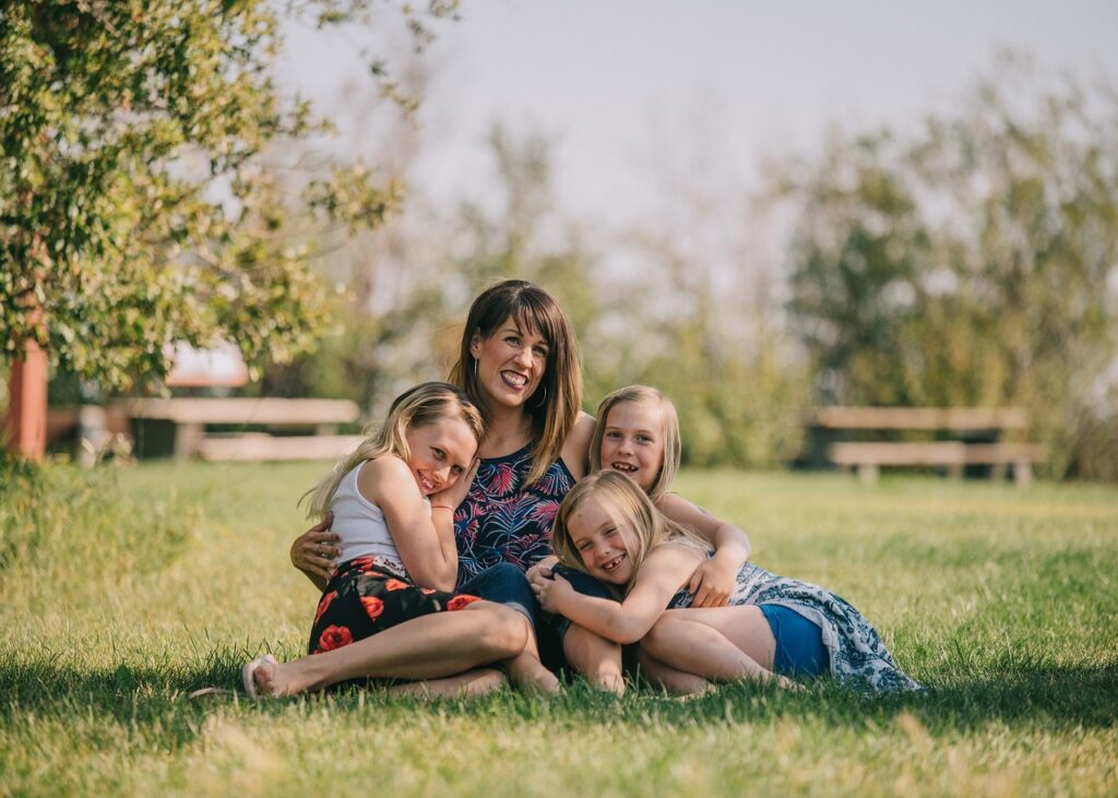 mother and children sitting on grass