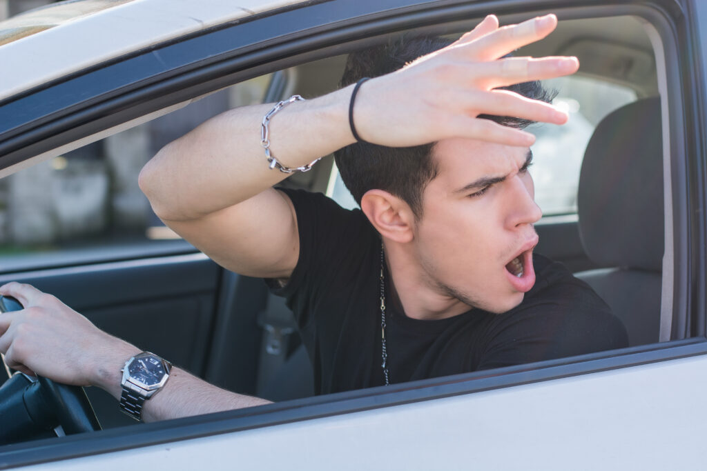 Young man shouting out his car