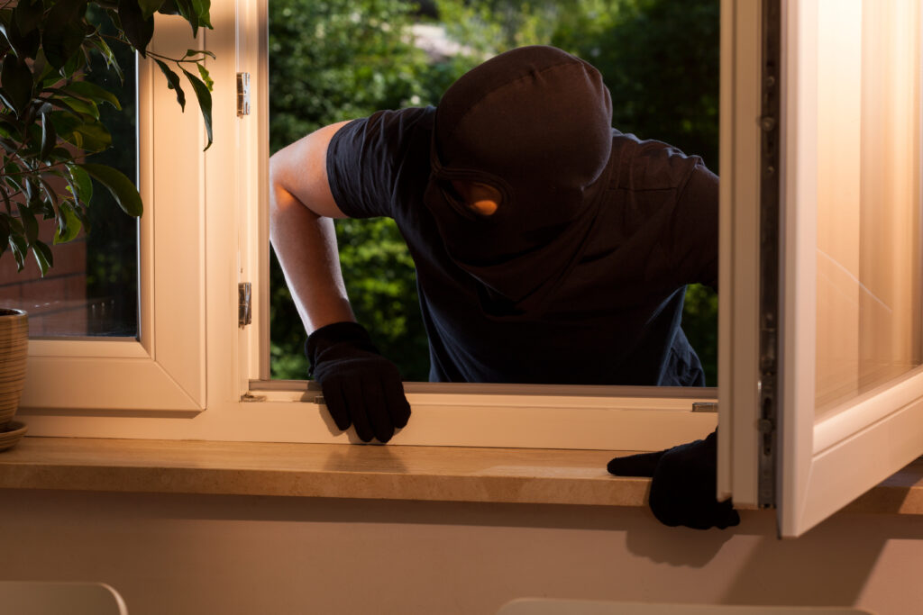 Burglar climbing through home window