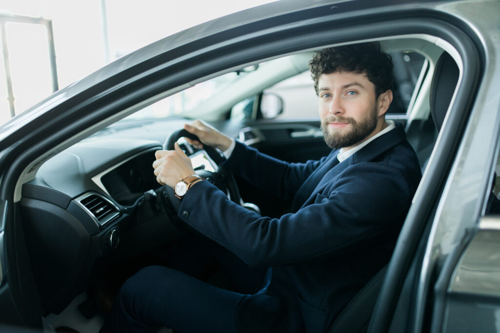 Young man sitting in car driving seat