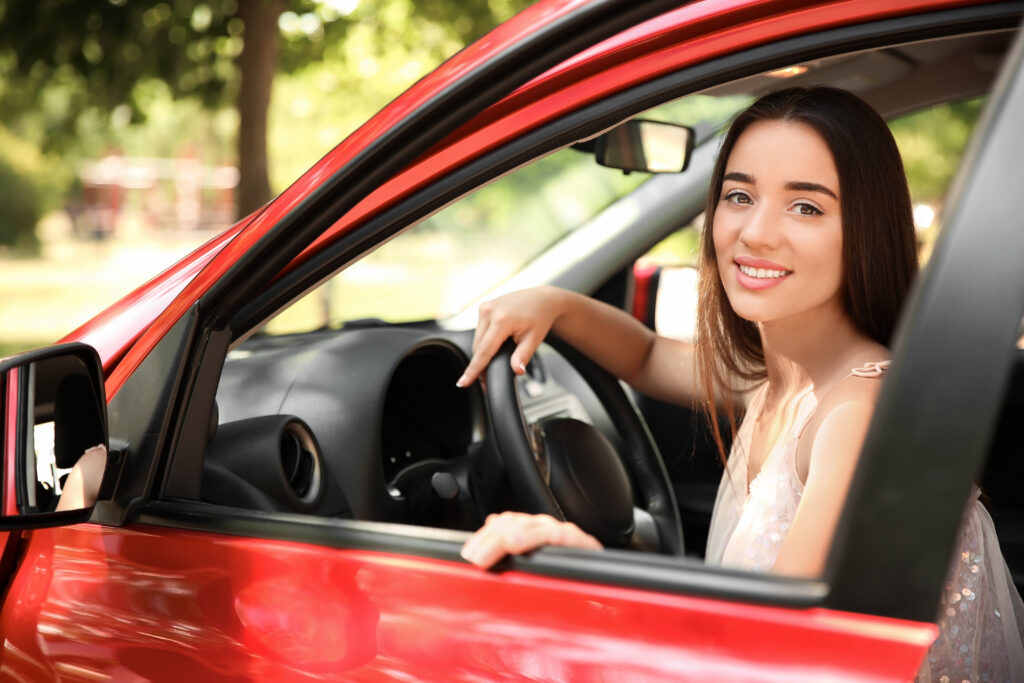 Teenager in driving side of car